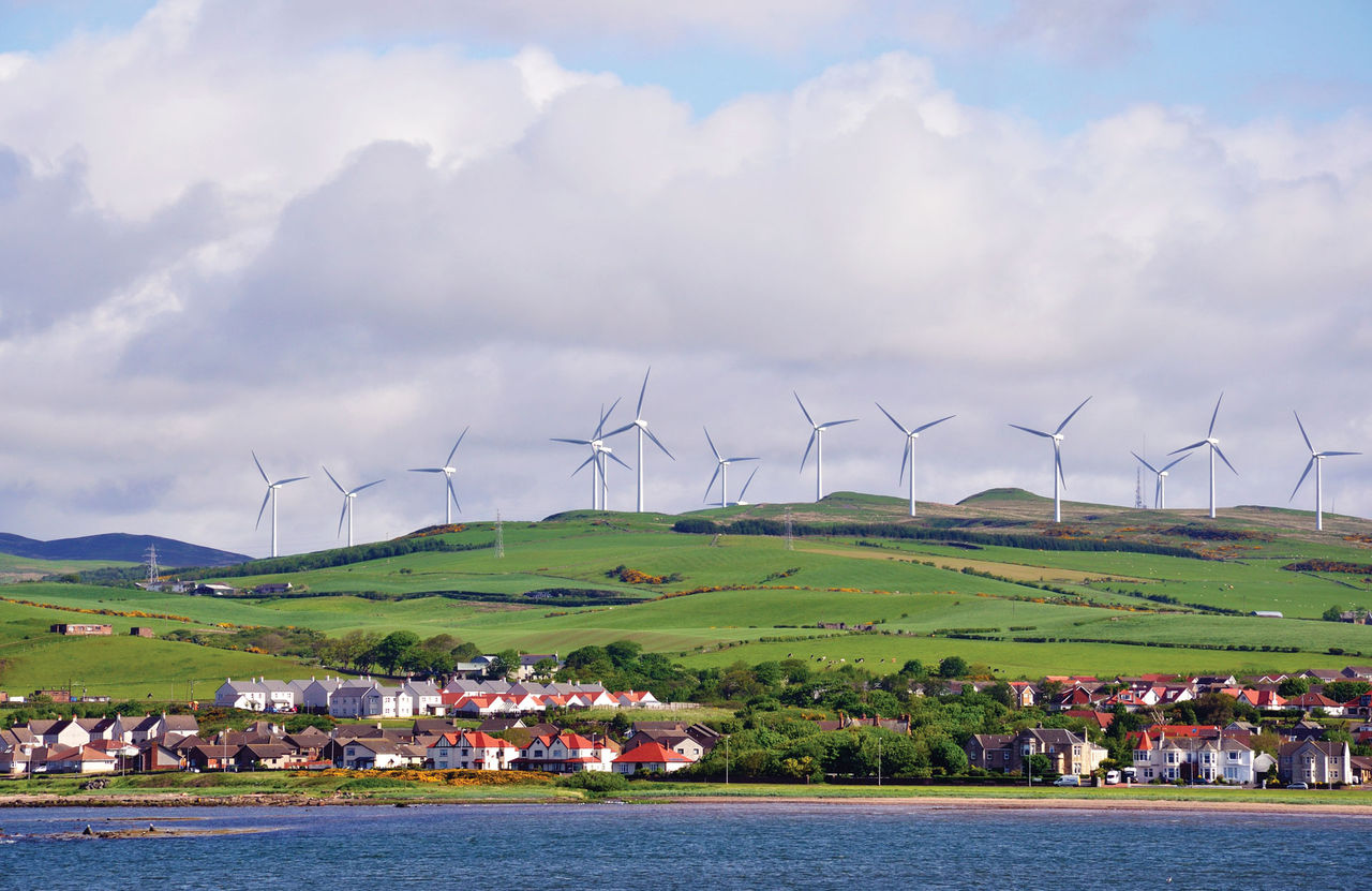 Wind turbines on a hill overlooking a town