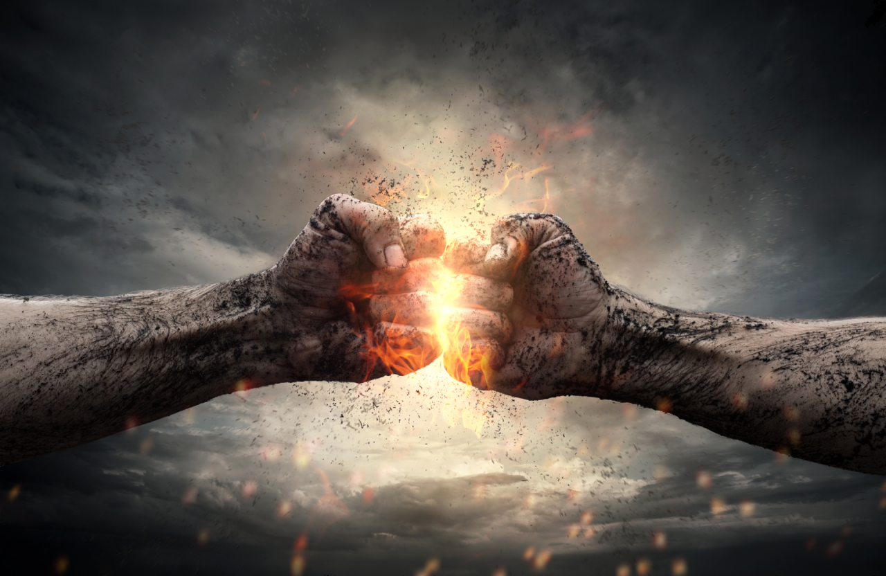 Fight, close up of two fists hitting each other over dramatic sky