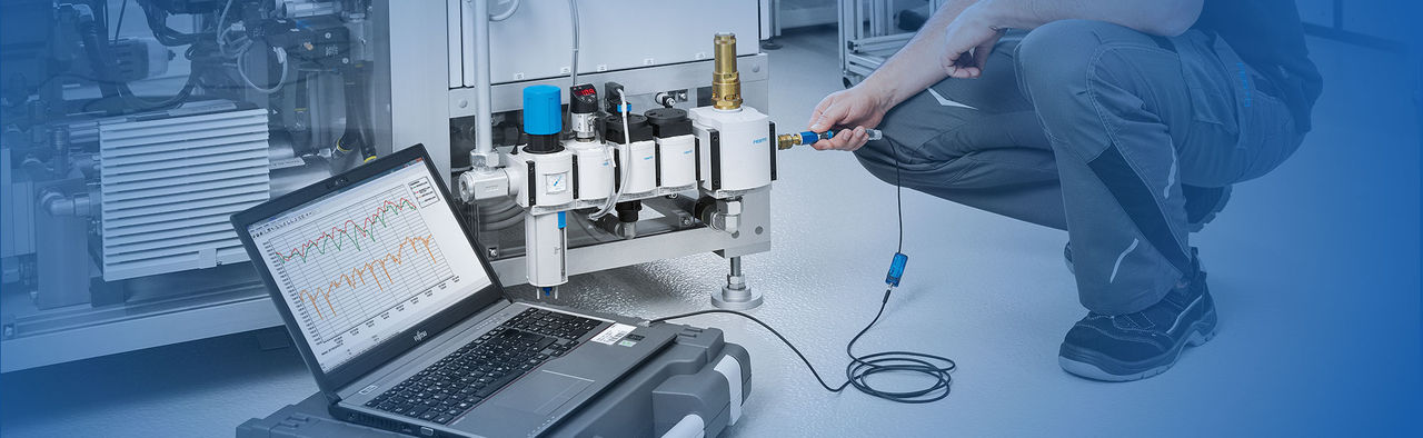 Festo work man testing the products to see if they're not wasting energy or money with a monitor machine in a clean testing setting